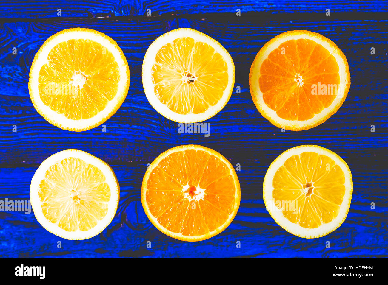 Limone e fettine di arancia sul blu sullo sfondo di legno vista superiore Foto Stock