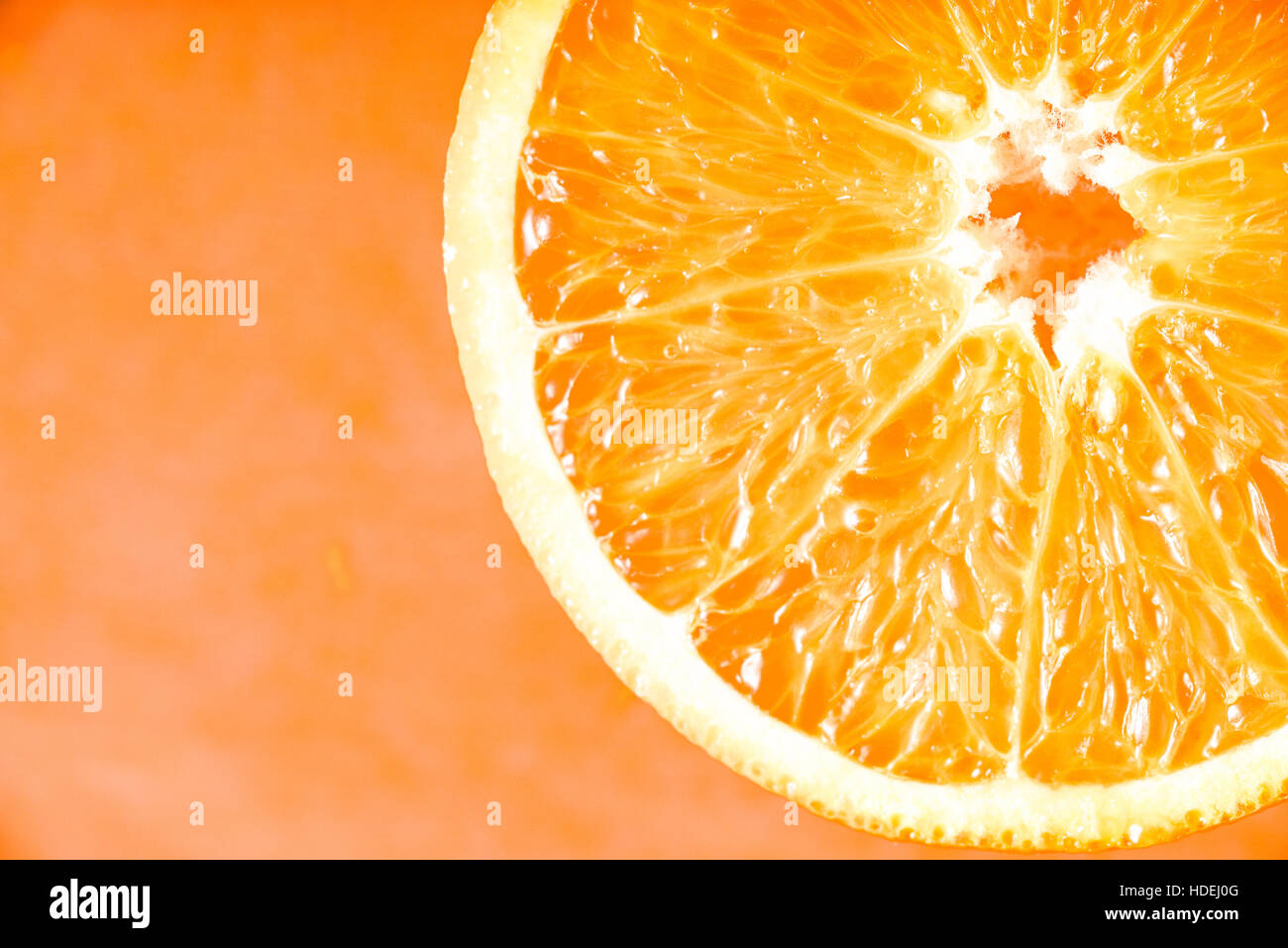 Fetta di arancia sullo sfondo di terracotta close-up Foto Stock
