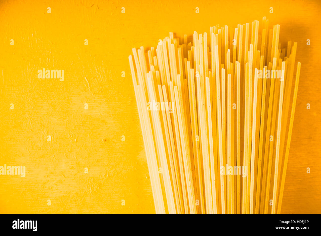 Materie spaghetti su sfondo giallo orizzontale Foto Stock