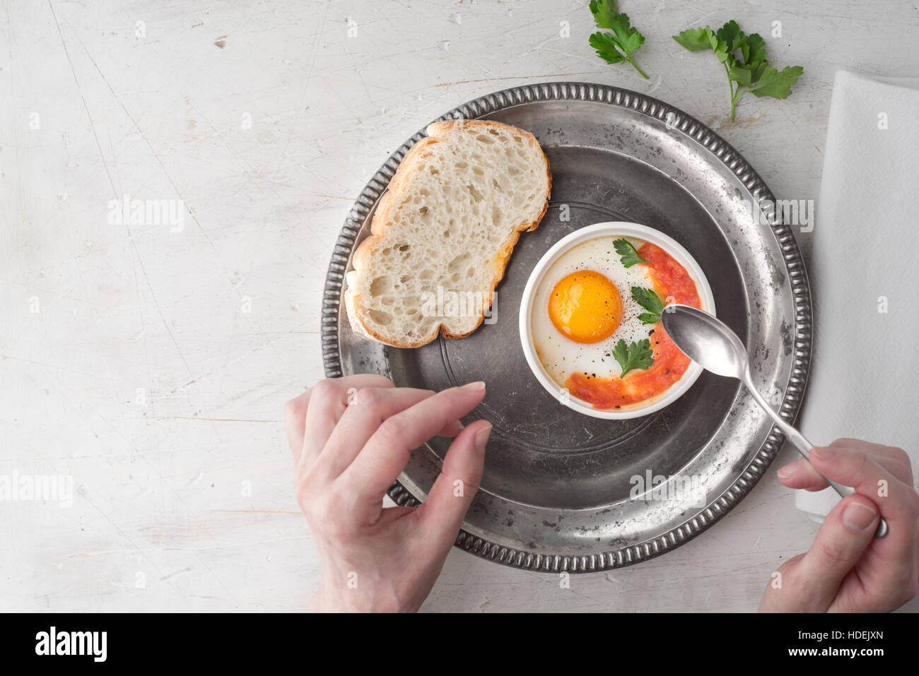 Mangiare uova al forno con pomodori e prezzemolo vista superiore Foto Stock