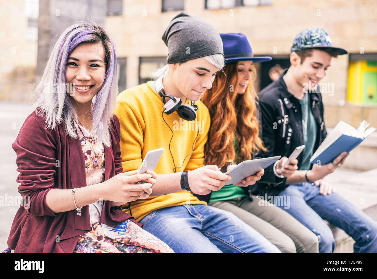 Gruppo multietnico di amici guardando giù al telefono e tablet, concetti sulla tecnologia della dipendenza e della gioventù Foto Stock