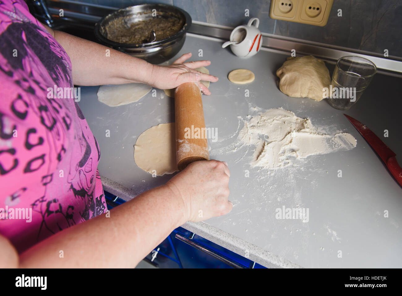 Nonna stendere l'impasto. Senior donna mani di stendere la pasta di farina  con il mattarello nella sua cucina domestica Foto stock - Alamy