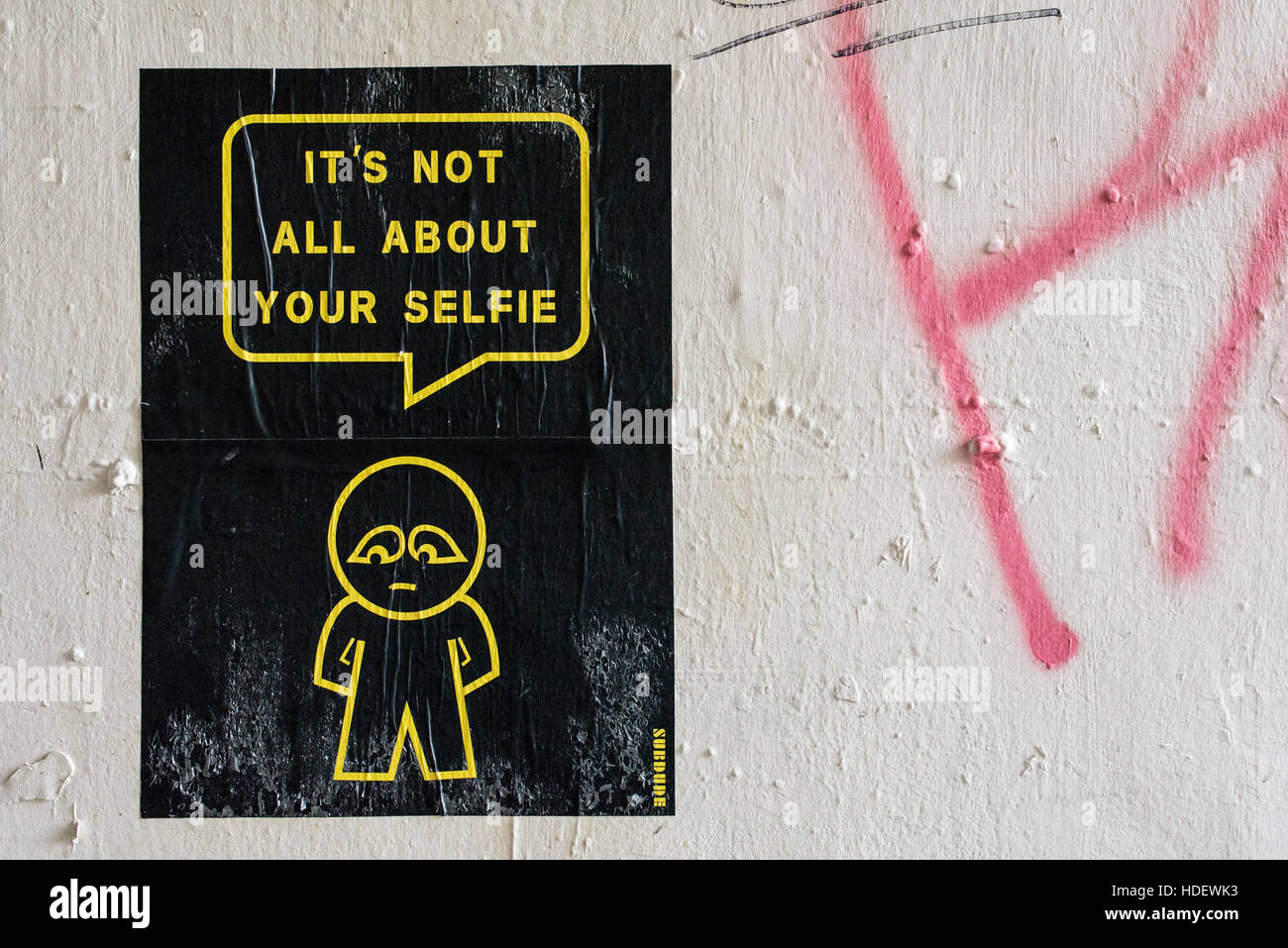 Street Art poster appeso al muro bianco da artista SUBDUDE con uomo stilizzato e fumetti con slogan "Non è tutto circa il vostro selfie' Foto Stock