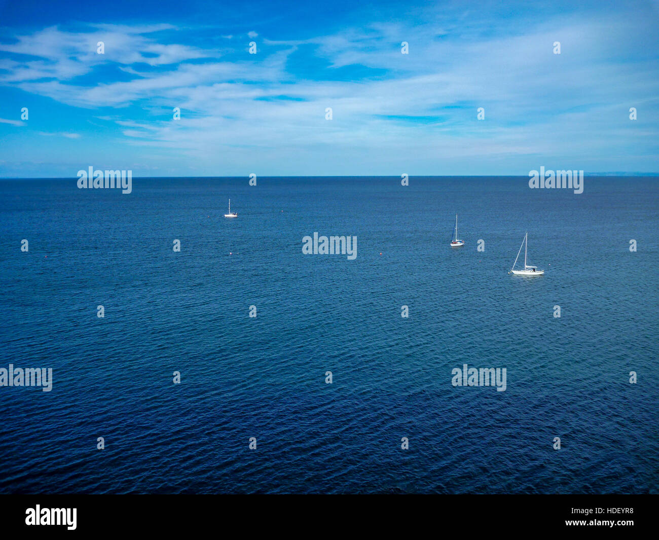 Guardando verso il basso su tre barche da st Ann la testa sull'approccio a Milford haven. cirrus nubi in un cielo blu e increspature sul mare Foto Stock