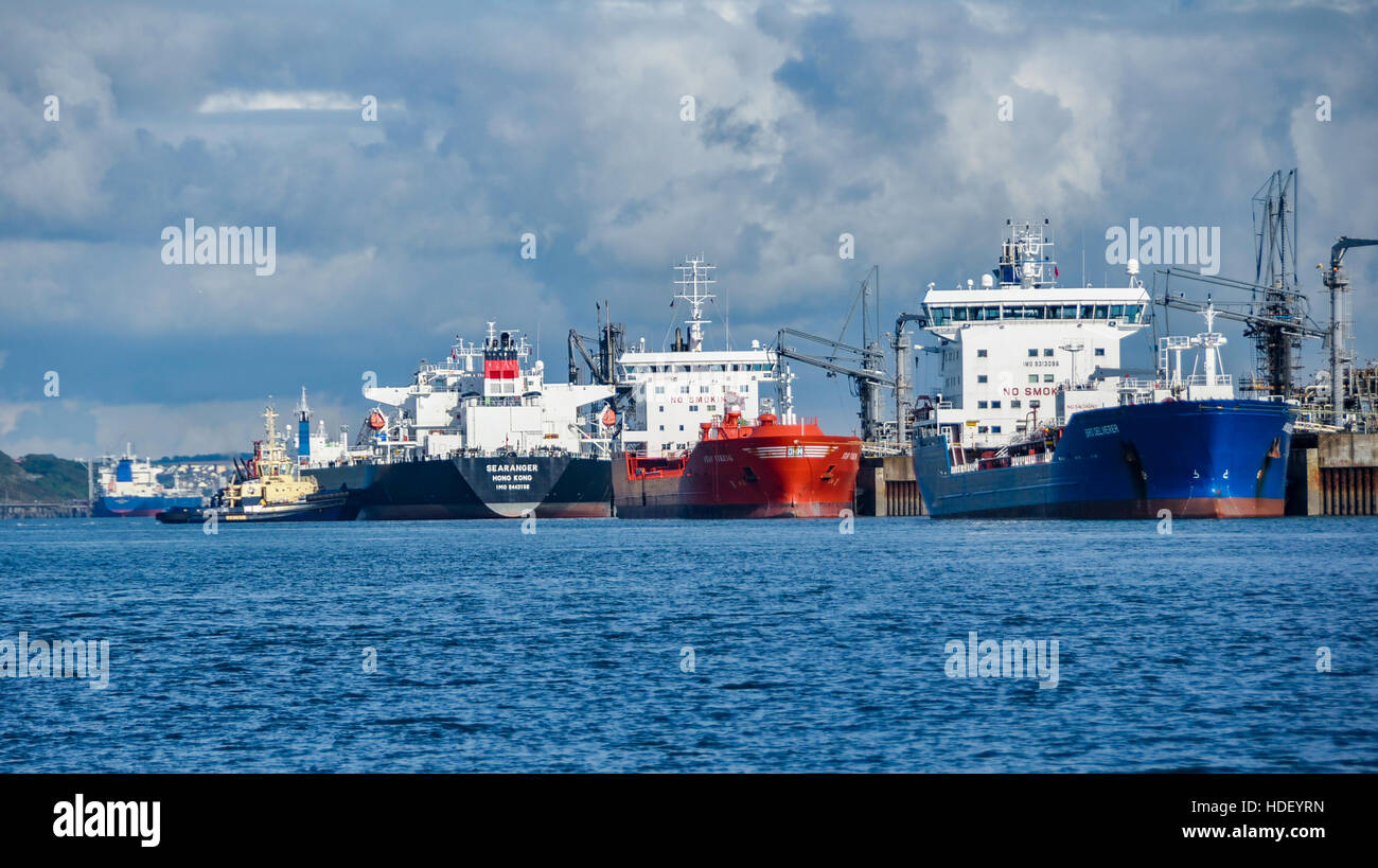 Supertankers ai loro posti barca in Milford haven in pembrokeshire e uno appena arrivati con l aiuto dei rimorchiatori locale Foto Stock