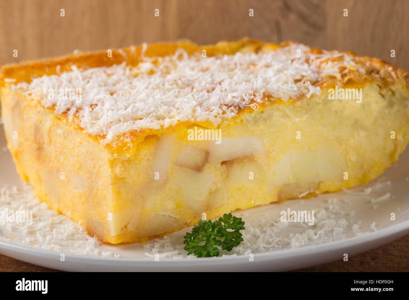 Polenta al forno con patate e formaggio e uova fracassato sulla piastra Foto Stock