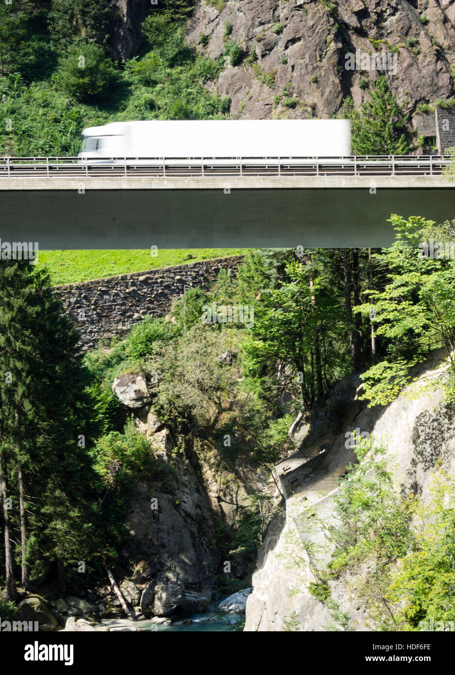 Un carrello sfocata è la guida su un ponte autostradale della Svizzera di autostrada A2 verso il tunnel del San Gottardo attraverso le alpi svizzere. Foto Stock