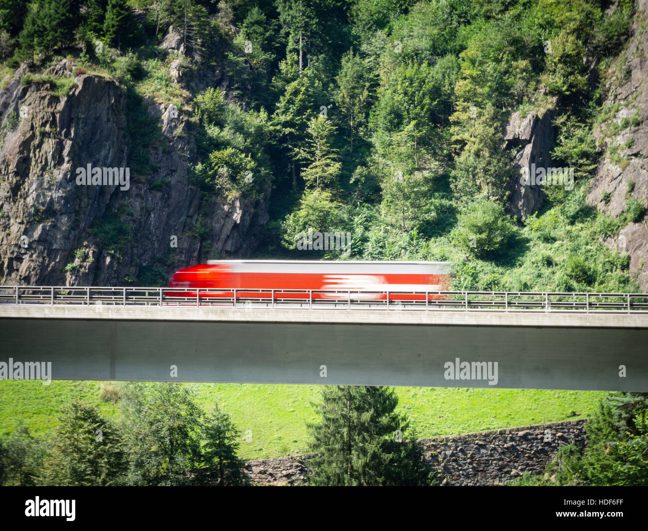 Un carrello sfocata è la guida su un ponte autostradale della Svizzera di autostrada A2 verso il tunnel del San Gottardo attraverso le alpi svizzere. Foto Stock