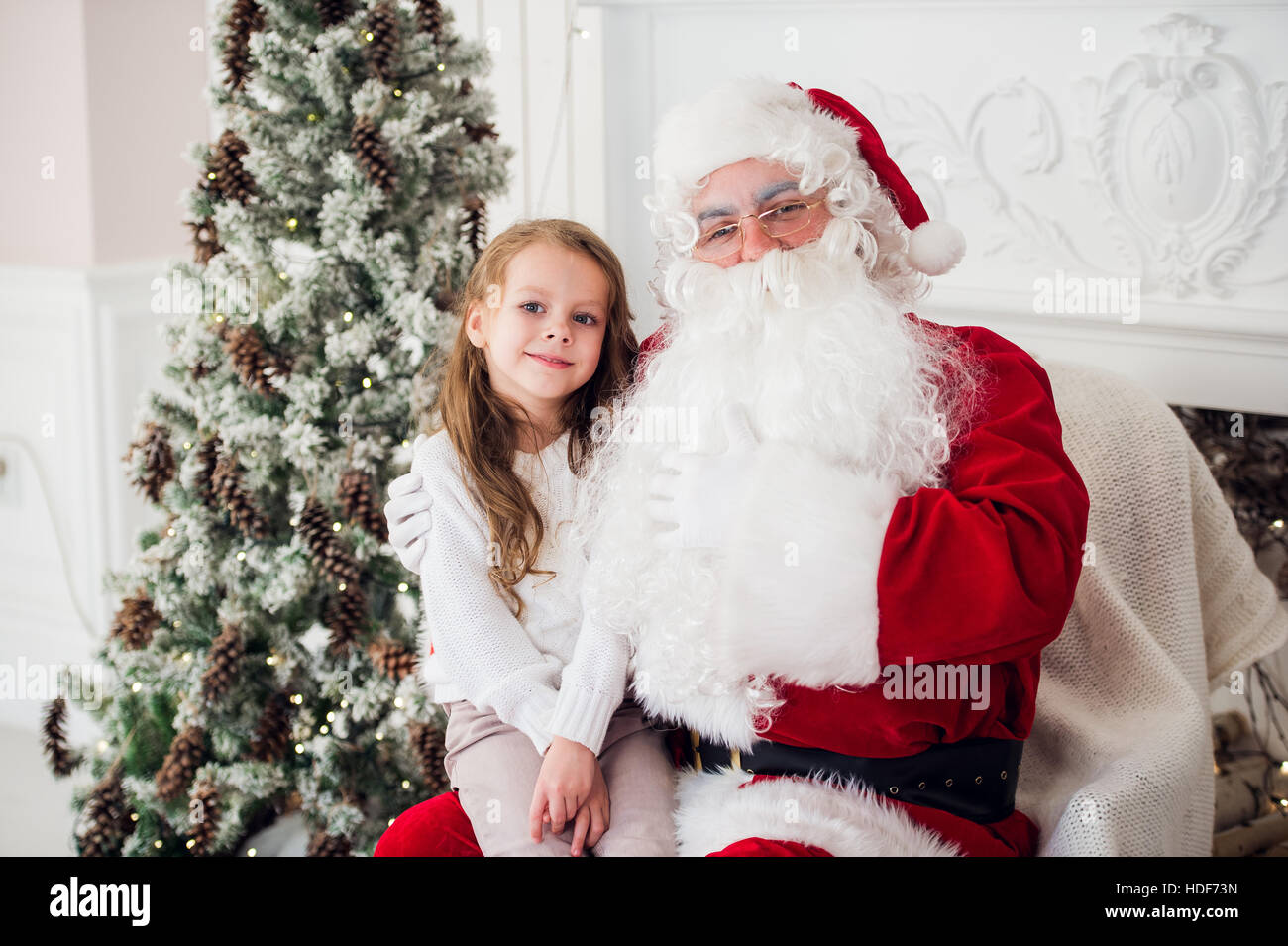 Bambina parlando con un vecchio Babbo Natale Foto Stock