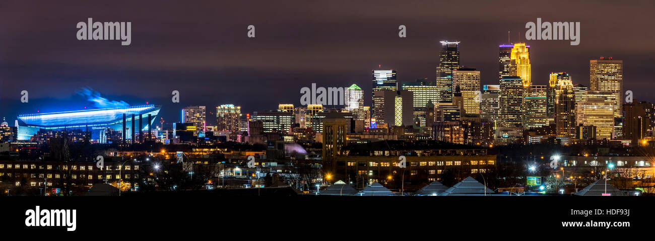 Usbank stadium vestito in viola con il Minneapolis skyline illuminata intensamente per un Minnesota Vikings giovedì notte gioco di calcio. Foto Stock
