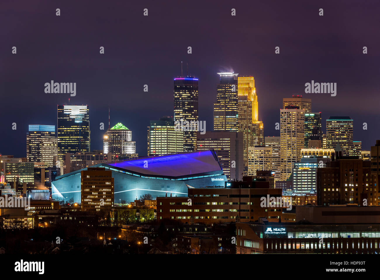 Usbank stadium vestito in viola con il Minneapolis skyline illuminata intensamente per un Minnesota Vikings giovedì notte gioco di calcio. Foto Stock