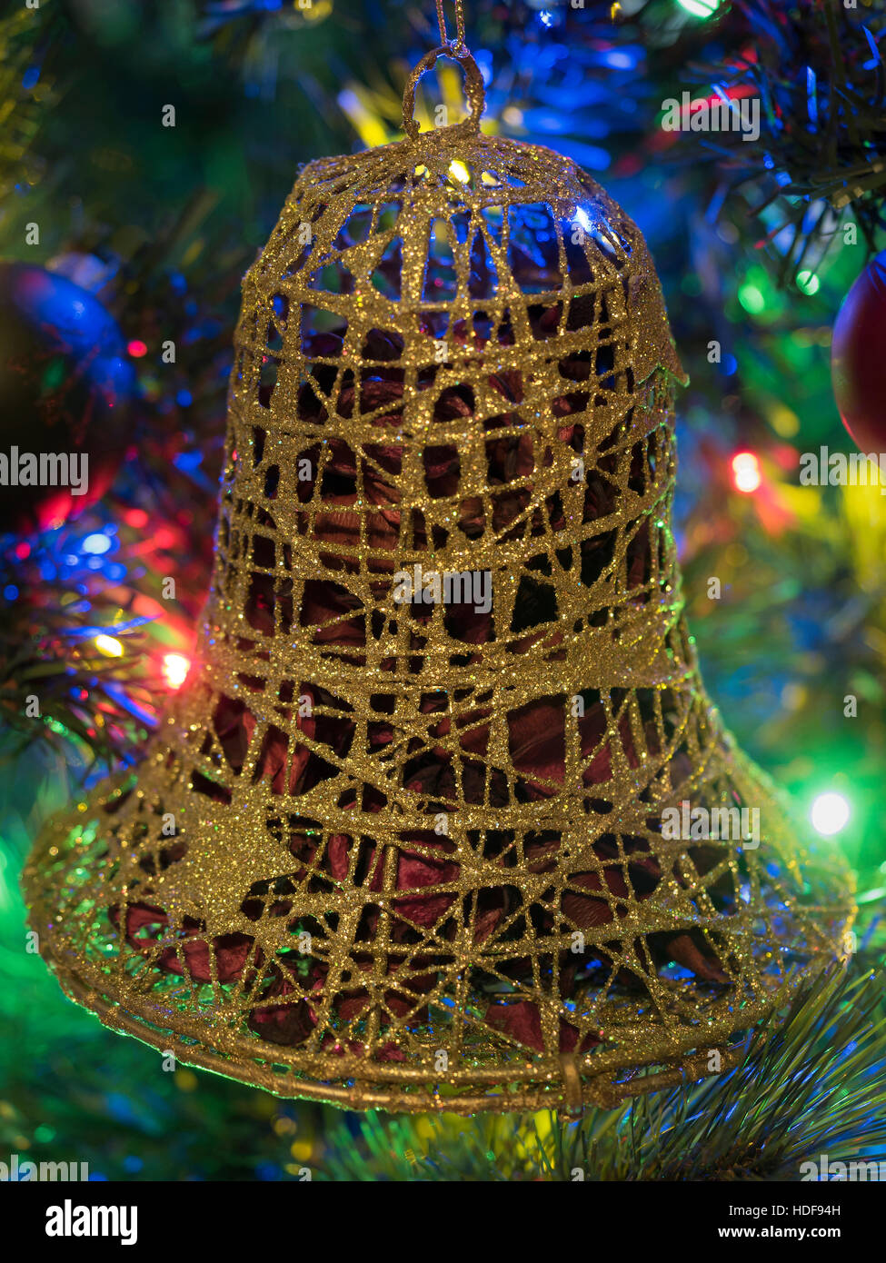 Golden bell decorare un albero di Natale illuminato Foto Stock