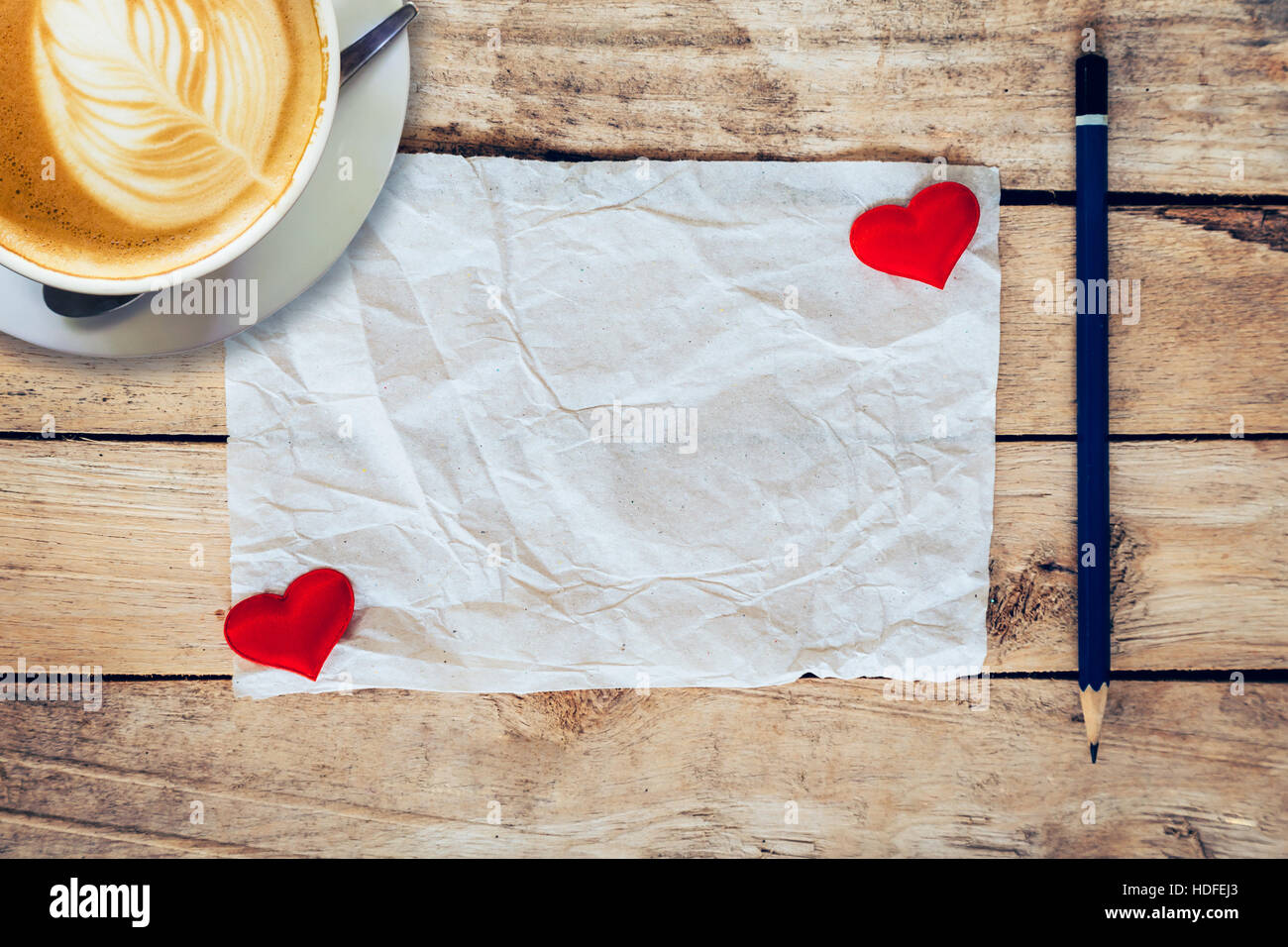 Vecchia carta e cuore rosso, tazza di caffè con matita su uno sfondo di legno per san valentino biglietto di auguri. Foto Stock