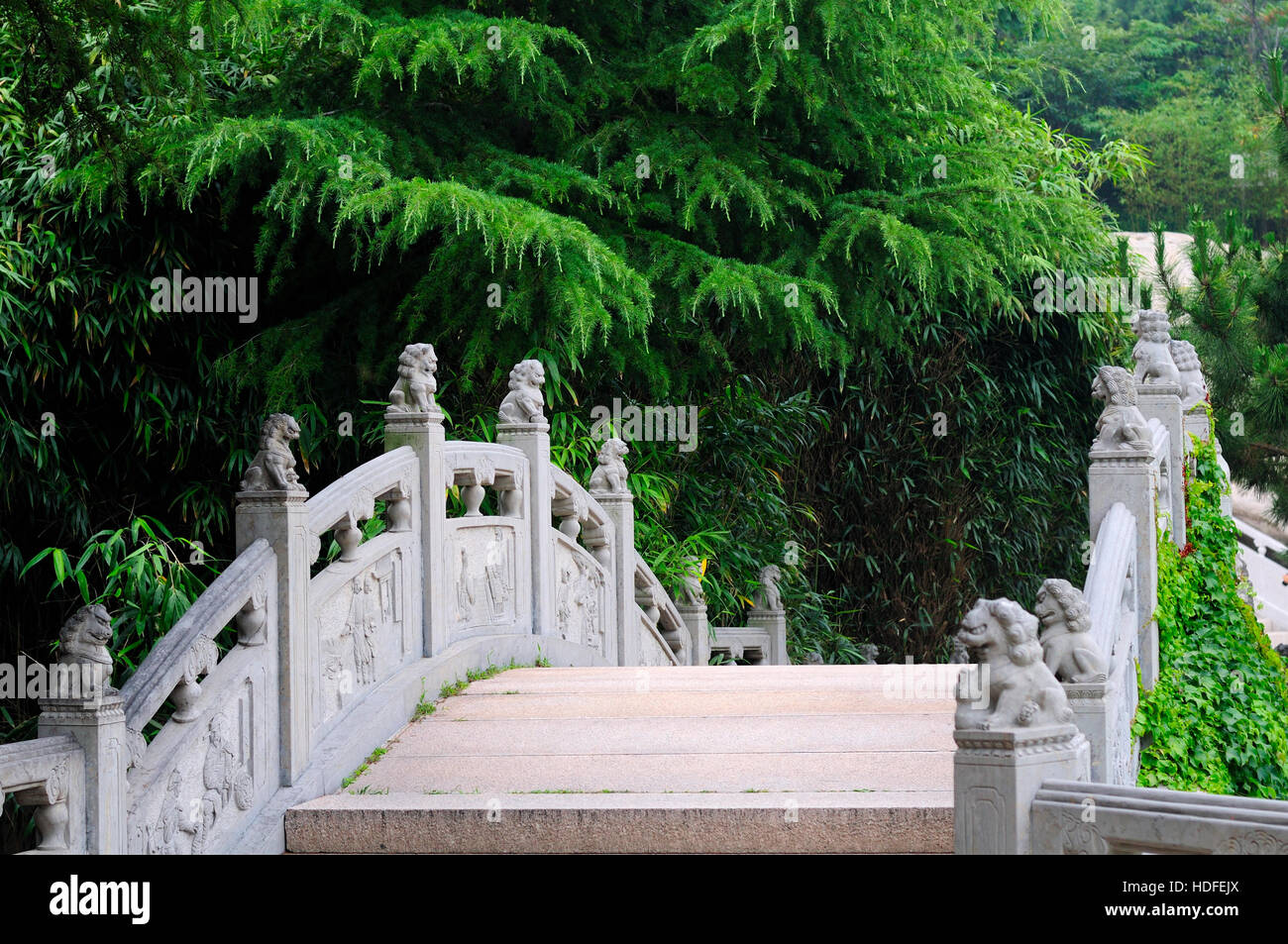 Cinese topping lions i posti di un ponte in pietra all'interno di Taiping Palace a Qingdao nella provincia dello Shandong Cina. Foto Stock