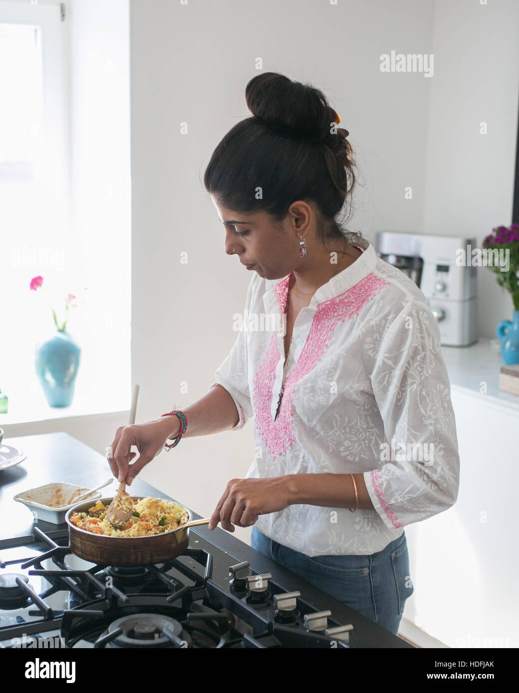 Giovane donna indiana in cucina a preparare il cibo ayurvedico Foto Stock