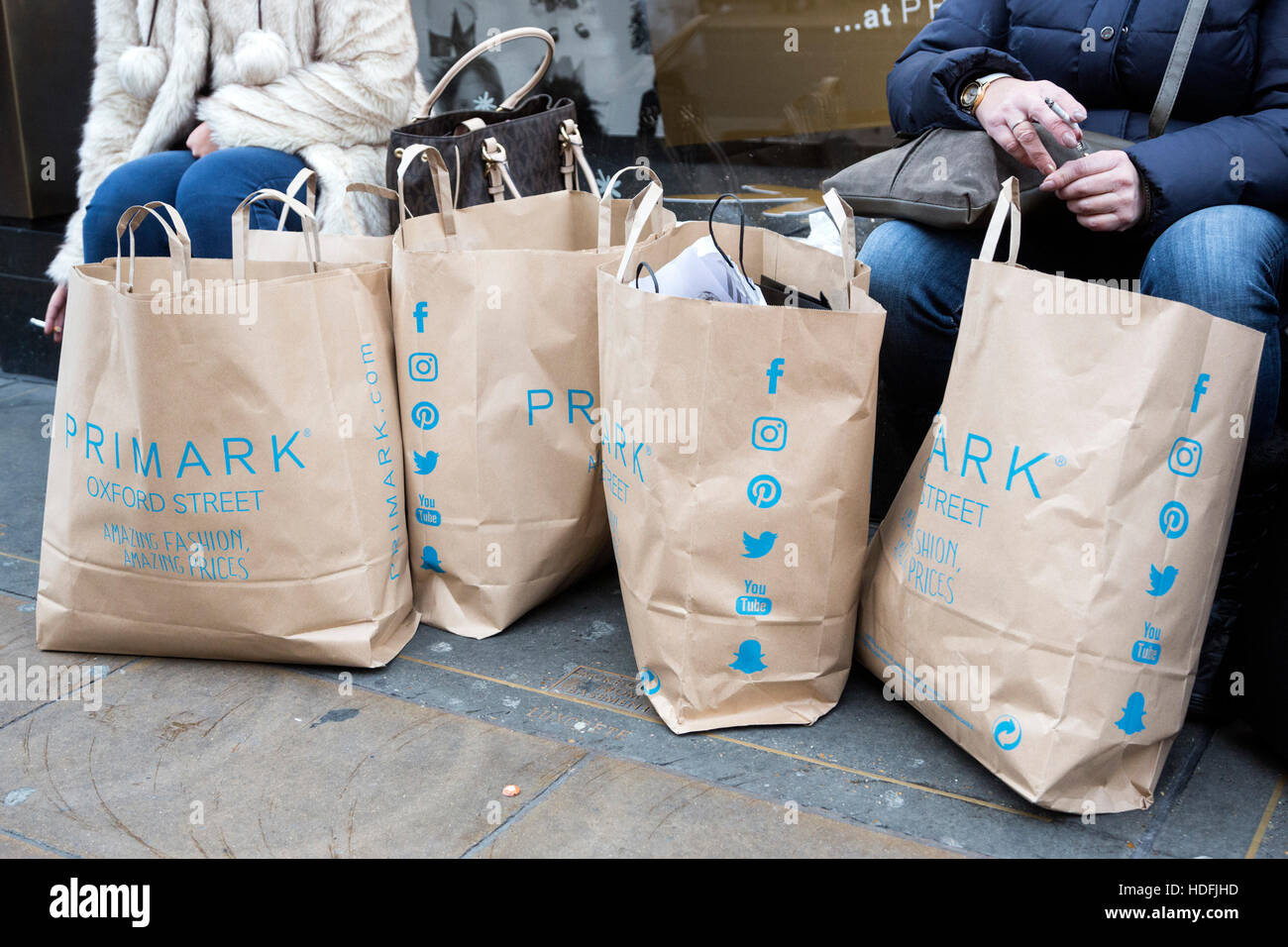 Gli amanti dello shopping con le borse della spesa da Primark. Giornata  intensa su Oxford Street nella corsa fino a Natale Foto stock - Alamy