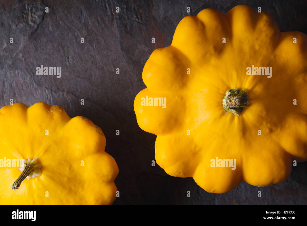 Giallo zucca freschi patty pan sulla pietra scura orizzontale di sfondo Foto Stock