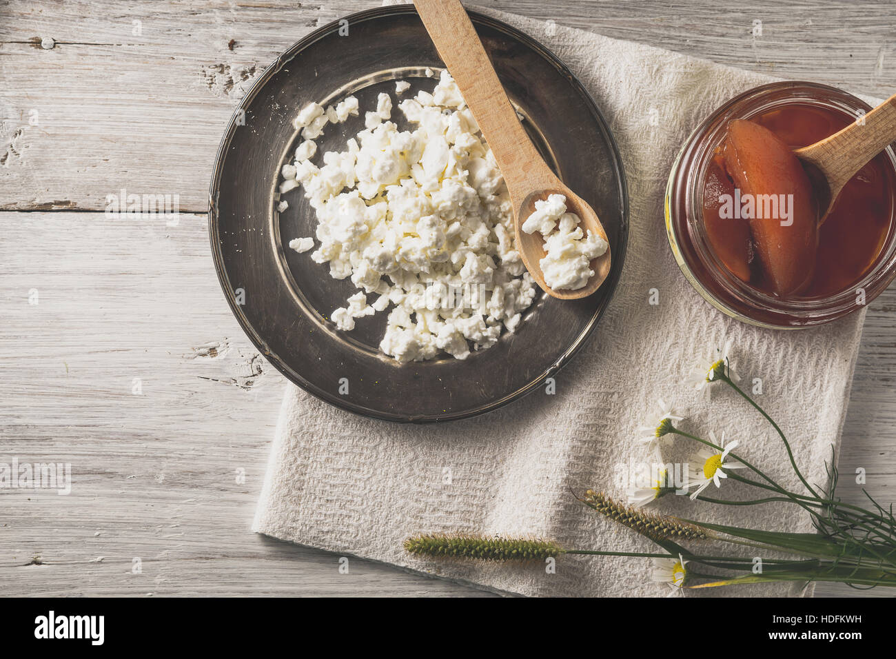 Fresco formaggio cottage con marmellata e fiori sul bianco tavolo in legno vista superiore Foto Stock