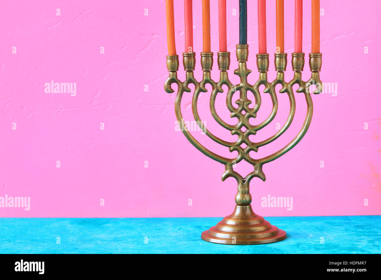 Hanukkah menorah con candele su sfondo rosa in orizzontale Foto Stock