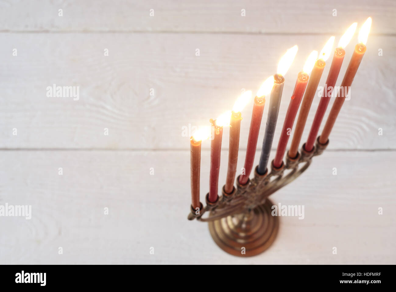 Hanukkah menorah con candele accese sul bianco tavolo in legno Foto Stock
