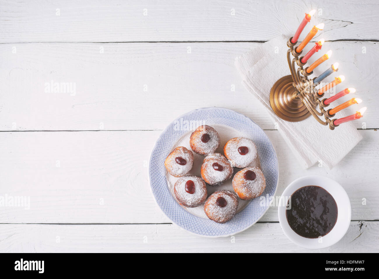 Hanukkah menorah e sufganiot sul bianco tavolo in legno vista superiore Foto Stock