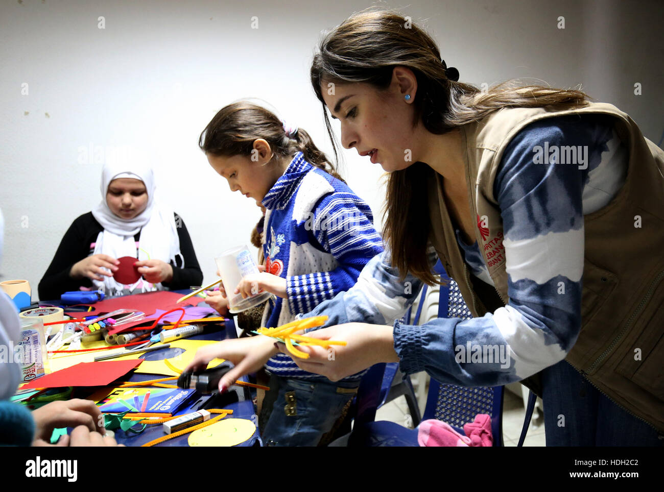 Psicologo Lina Zaarour corre un'arte terapia classe siriano per i bambini rifugiati presso un centro della Caritas nella valle della Bekaa regione del Libano. Le classi fanno parte della cura psicologica dato ai bambini per aiutarli a superare il trauma della guerra con arti e mestieri e giochi. Foto Stock