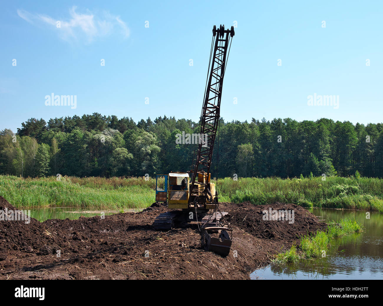 Escavatore sviluppando la torba sulla Palude in una giornata di sole Foto Stock