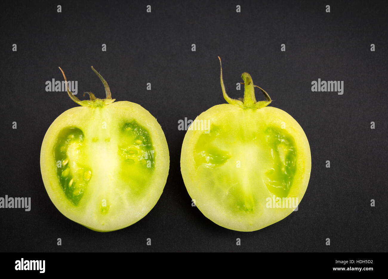 Crudo affettato i pomodori verdi sul backgeround scuro Foto Stock