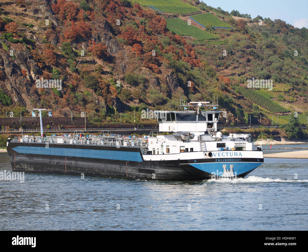 Una nave naviga lungo il Reno, una via d'acqua chiave in Europa, vitale per i trasporti e il commercio. Il fiume funge da importante rotta commerciale, con questa immagine che cattura un momento di attività marittima su uno dei fiumi più significativi d’Europa. Foto Stock