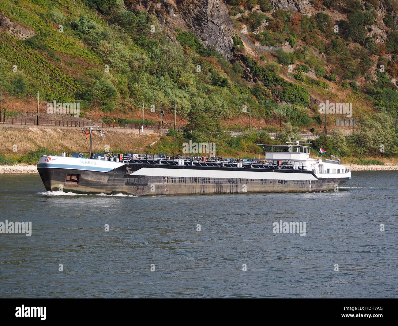 L'Icarus, una nave registrata in base alla norma ENI 02325626, è raffigurata navigando sul fiume Reno vicino a Oberwesel, in Germania, evidenziando il suo ruolo nel trasporto via acqua lungo questa storica via d'acqua. Foto Stock