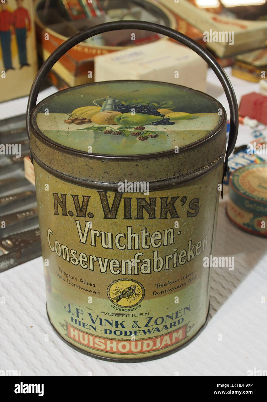 Questa immagine raffigura una lattina vintage di NV Vink huishoudjam, una tradizionale marmellata domestica. Il design della lattina riflette gli stili di confezionamento della sua epoca, offrendo una panoramica sul marketing alimentare storico e sulla progettazione dei prodotti. Foto Stock