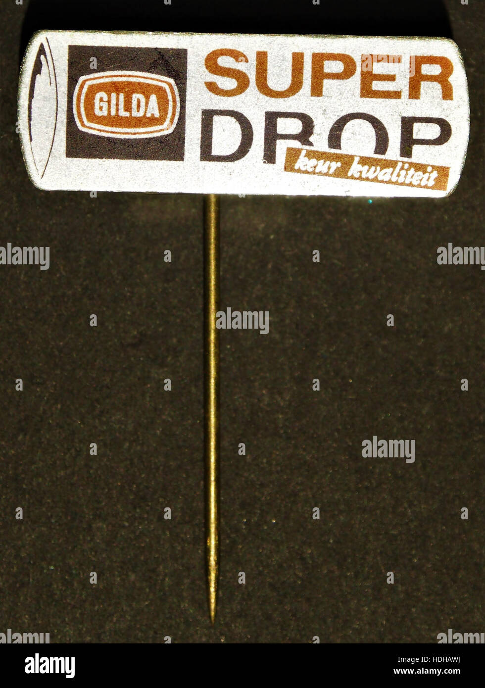 Questo pezzo vintage, etichettato come "Gilda Super Drop speltje", si riferisce a un oggetto da collezione, possibilmente un oggetto decorativo o gioielli, associato al marchio "Gilda Super". L'oggetto probabilmente riflette l'estetica del design della metà del XX secolo. Foto Stock