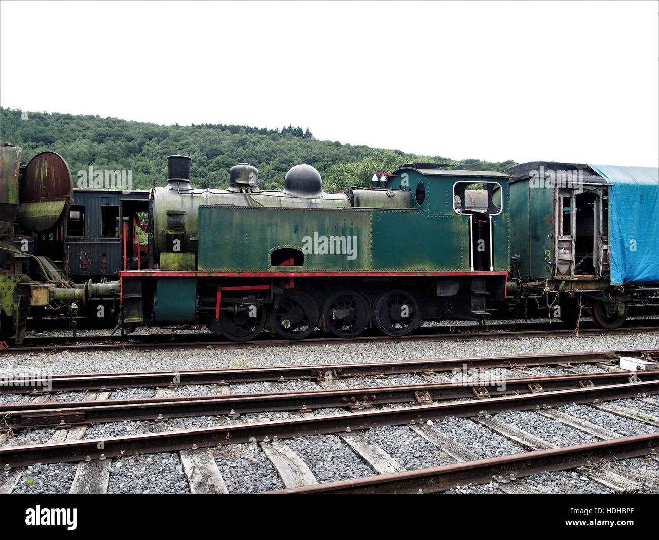 Questa immagine mostra una vecchia locomotiva a vapore presso il museo ferroviario di Treignes, Belgio. Il motore a vapore, un tempo cavallo dell'era industriale, mostra il design e l'artigianalità tipici della tecnologia ferroviaria del XIX secolo, dando uno sguardo all'evoluzione dei trasporti. Foto Stock