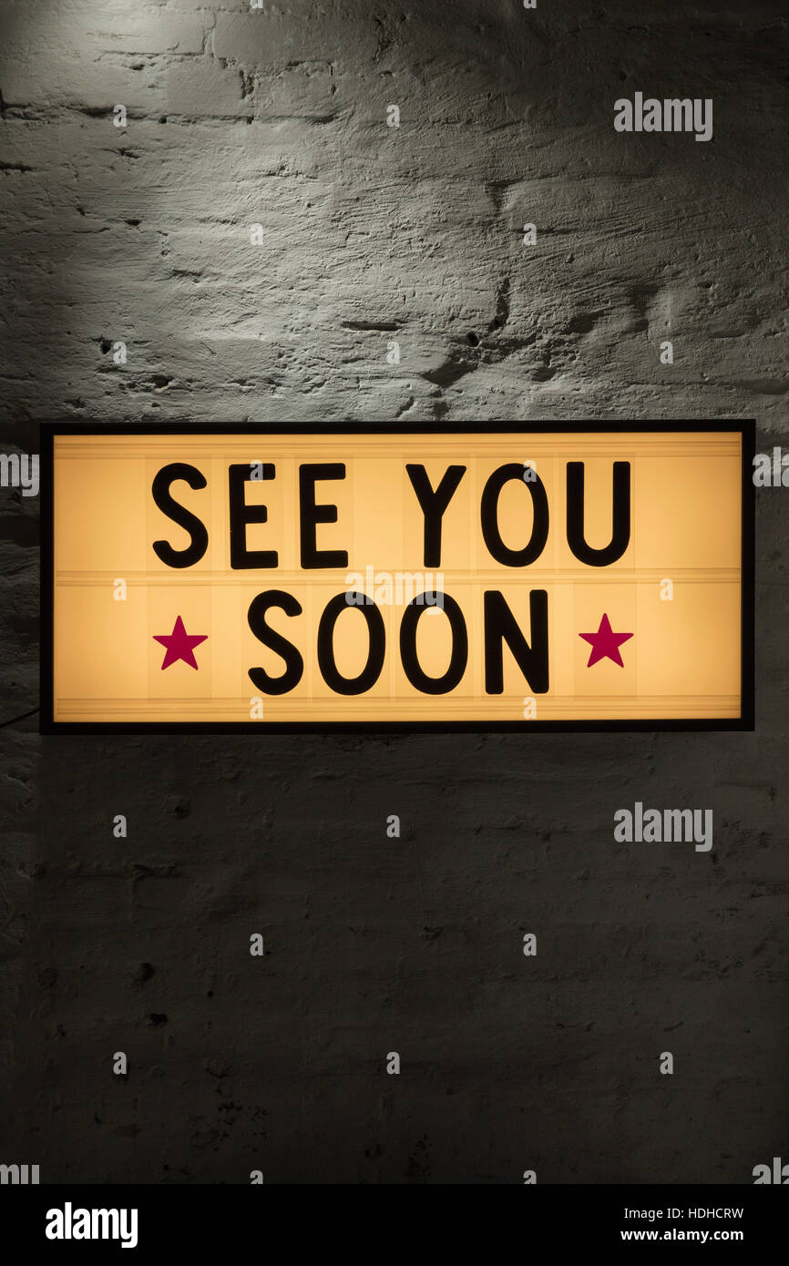 Close-up di vedervi presto cartello contro il muro grigio Foto Stock