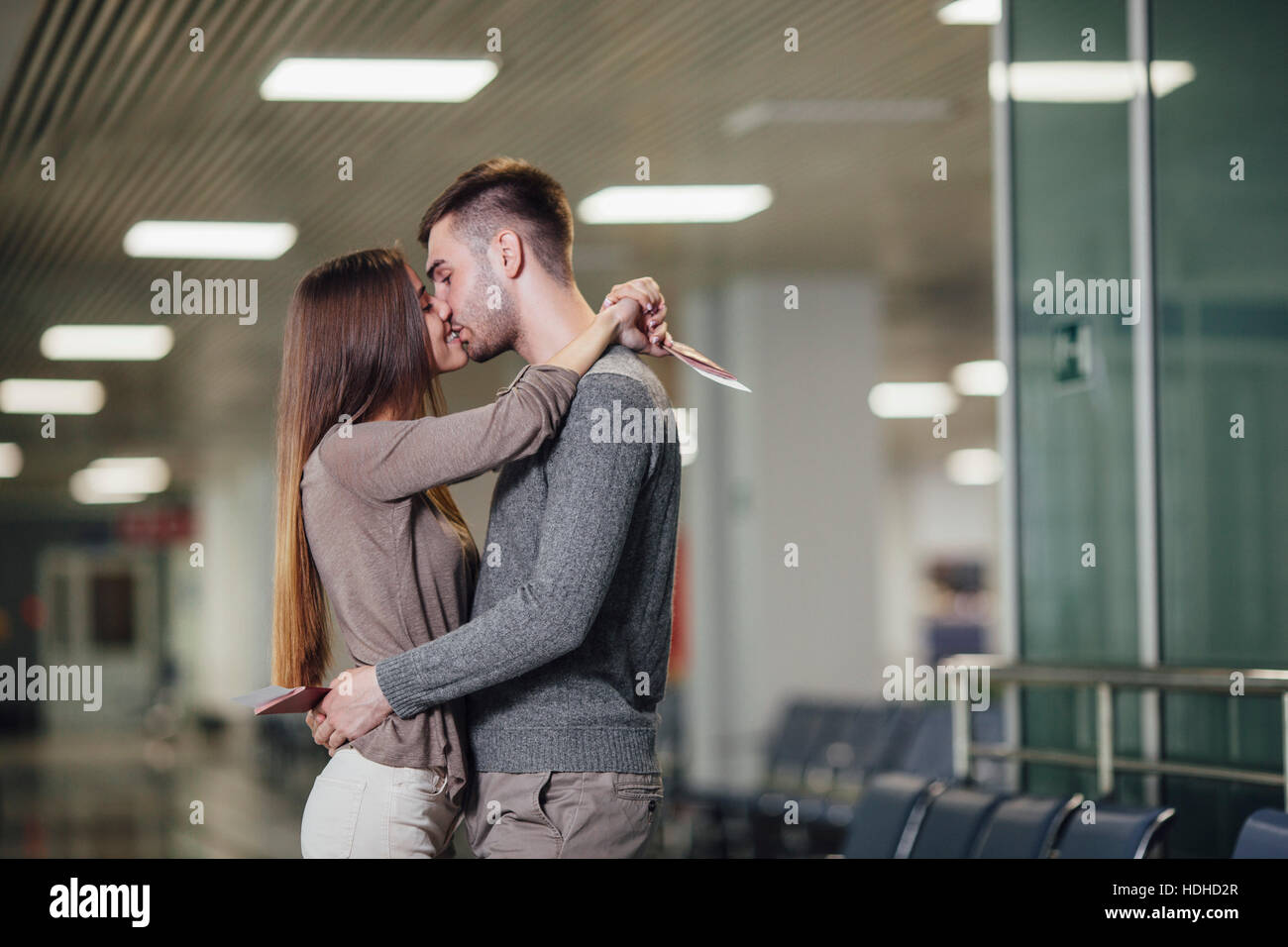 Vista laterale della romantica coppia giovane kissing all aeroporto Foto Stock