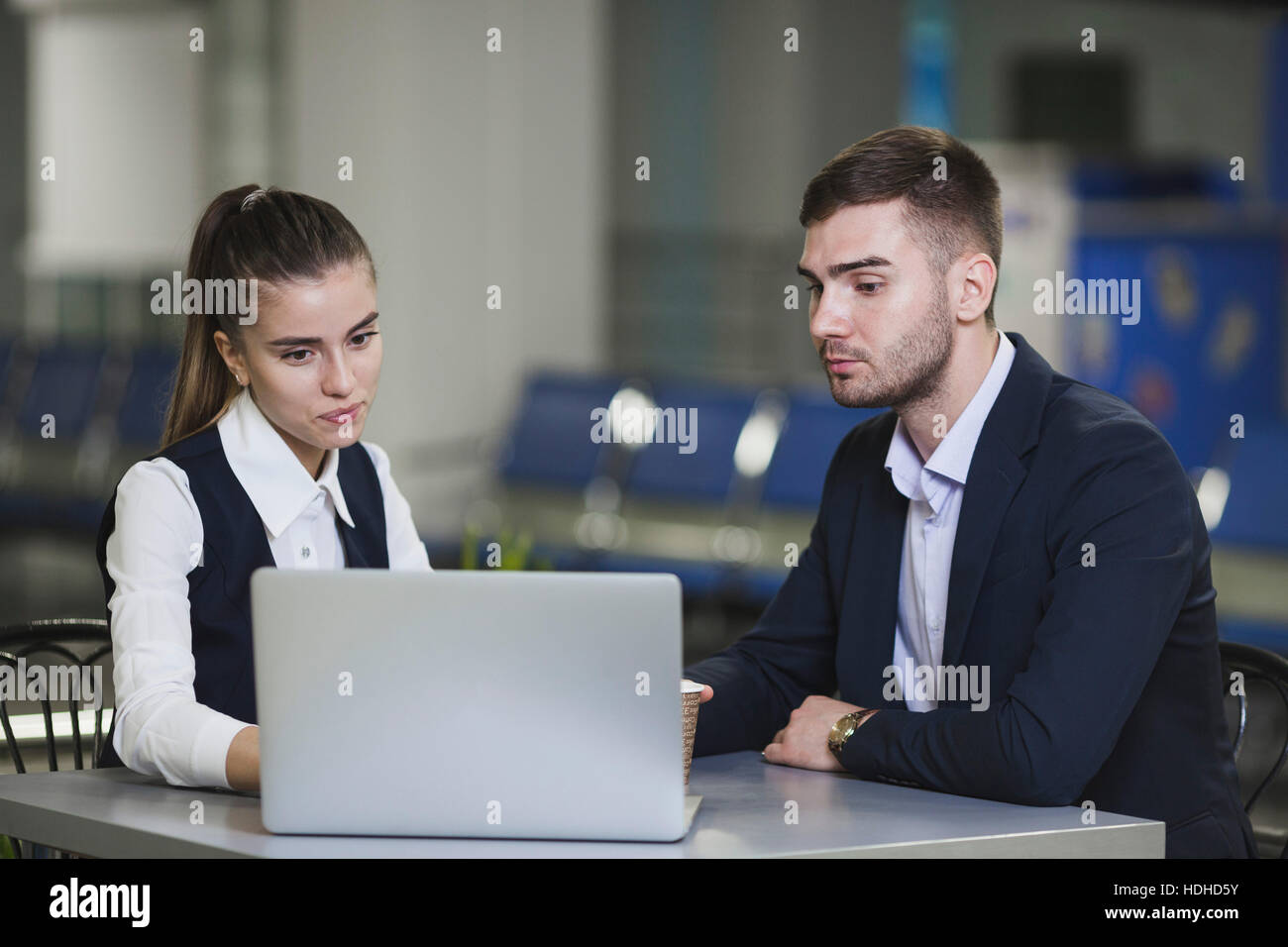 Giovane imprenditore e imprenditrice utilizzando il portatile in aeroporto Foto Stock