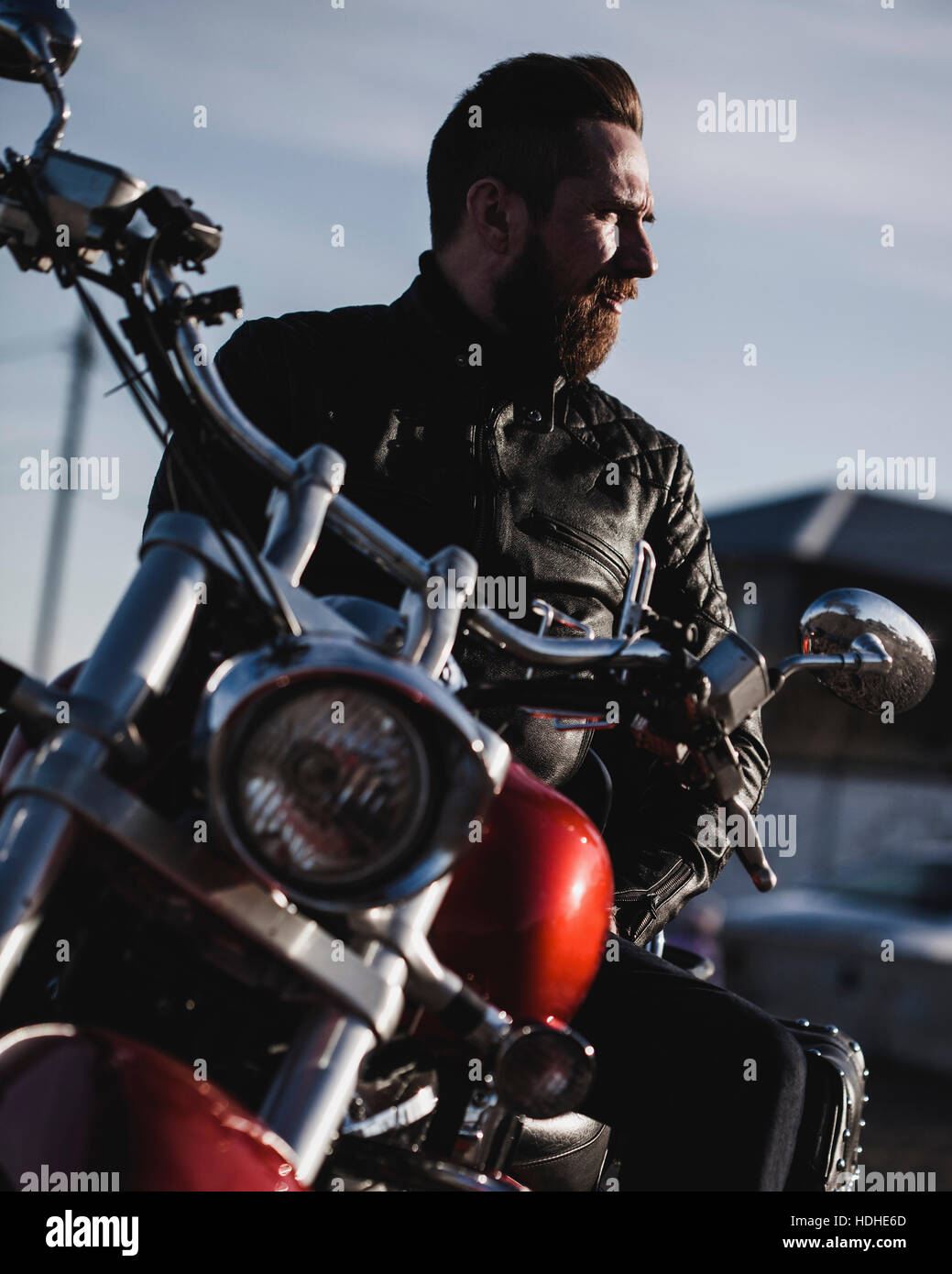 Ritratto di biker seduto sul motociclo e guardando lontano Foto Stock
