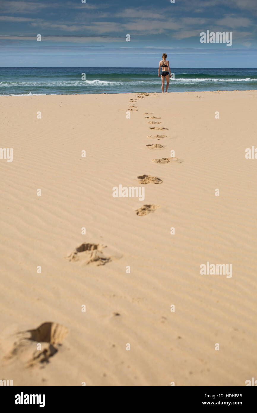 A metà distanza della donna alla spiaggia contro sky Foto Stock