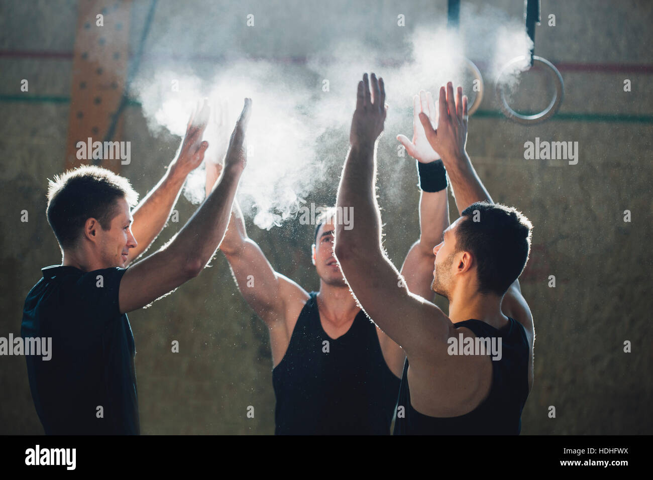 Determinati atleti maschio spolvero sport chalk insieme alla palestra Foto Stock