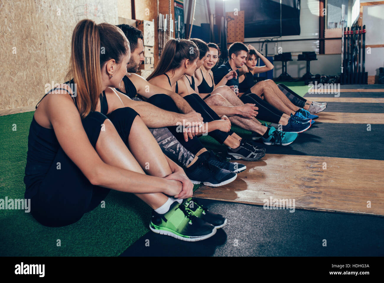 Maschio e femmina di atleti di parlare mentre è seduto su un tappeto o in palestra Foto Stock