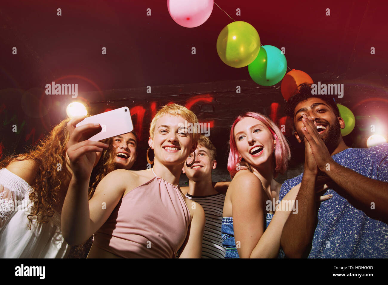 Angolo basso ritratto di donna felice tenendo selfie con gli amici in cantiere Foto Stock