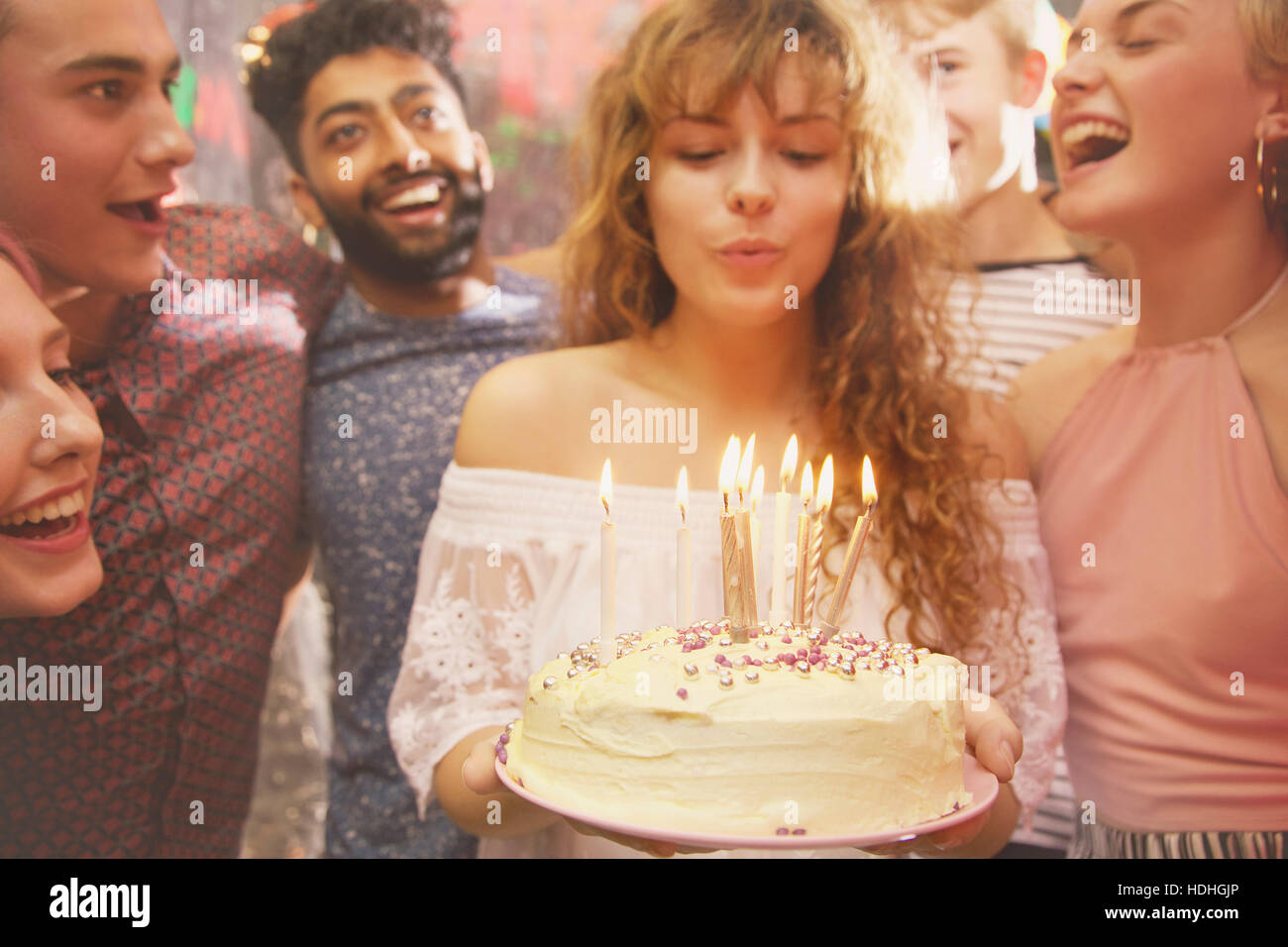 Donna candele di soffiaggio mentre festeggia il compleanno con gli amici Foto Stock