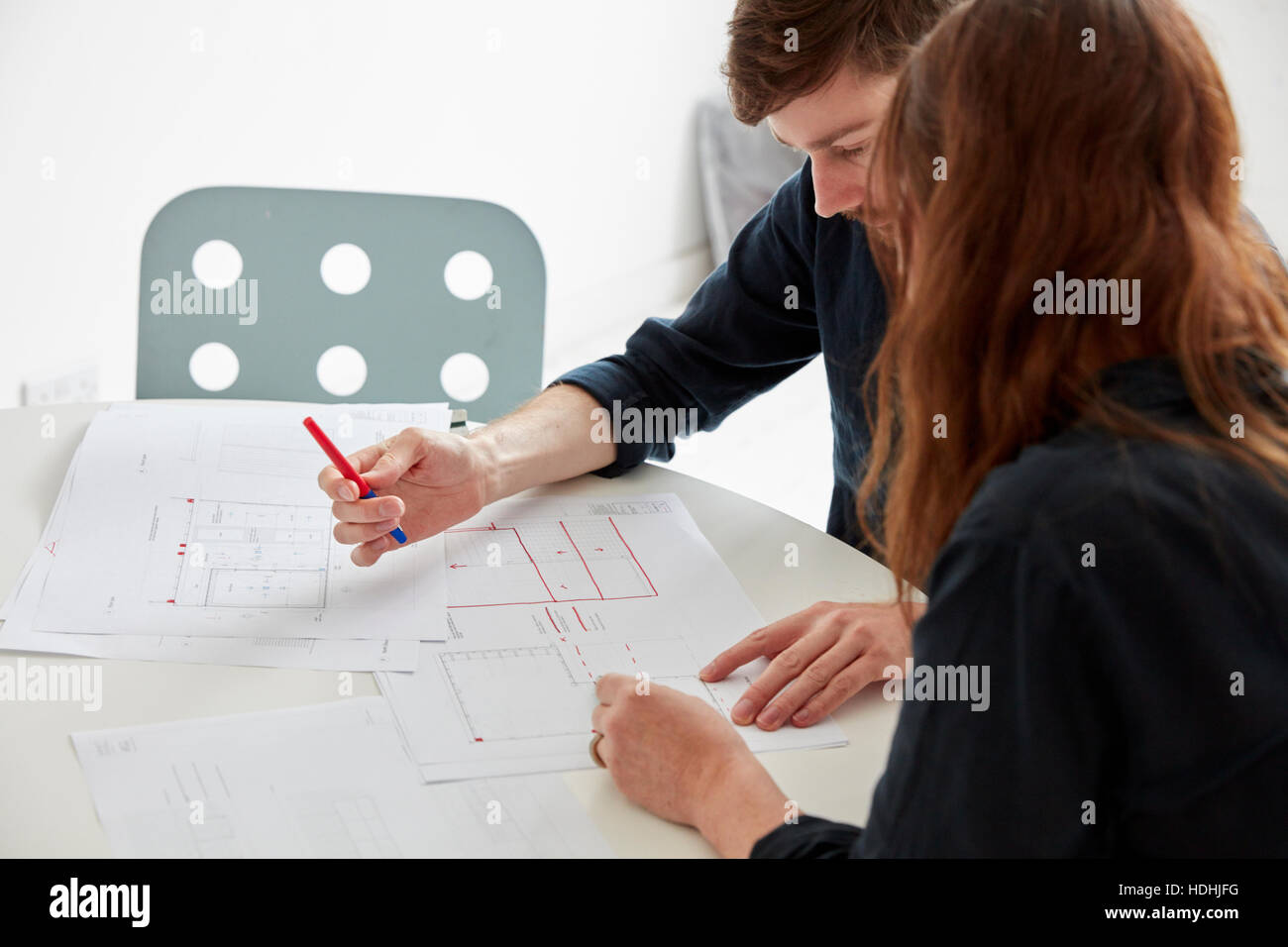 Un ufficio moderno. Due persone in una riunione per discutere i piani e disegni di disegni architettonici. Foto Stock
