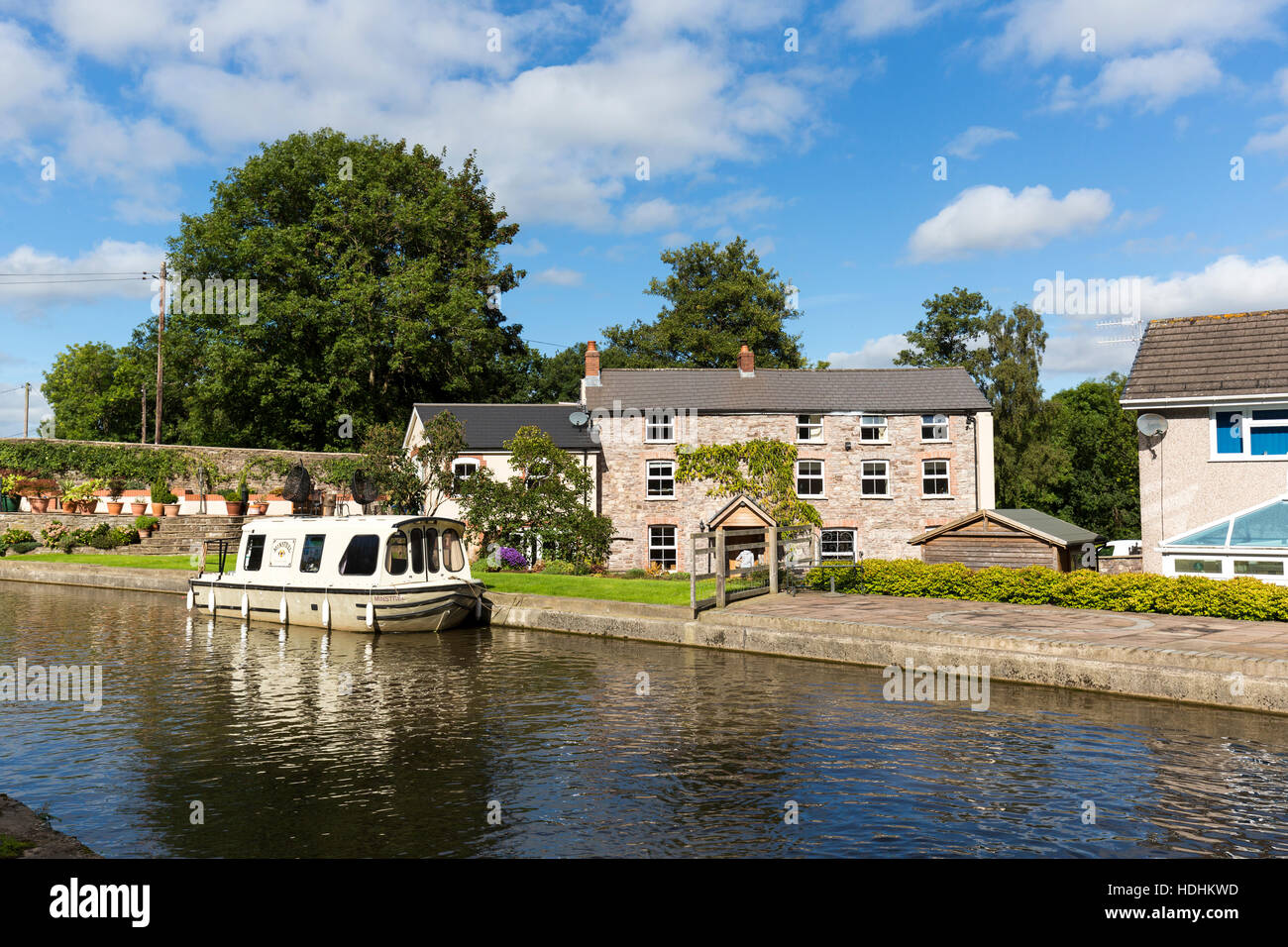 Barca ormeggiata in parte anteriore del case residenziali in Brecon e Monmouth canal, Govilon, Wales, Regno Unito Foto Stock