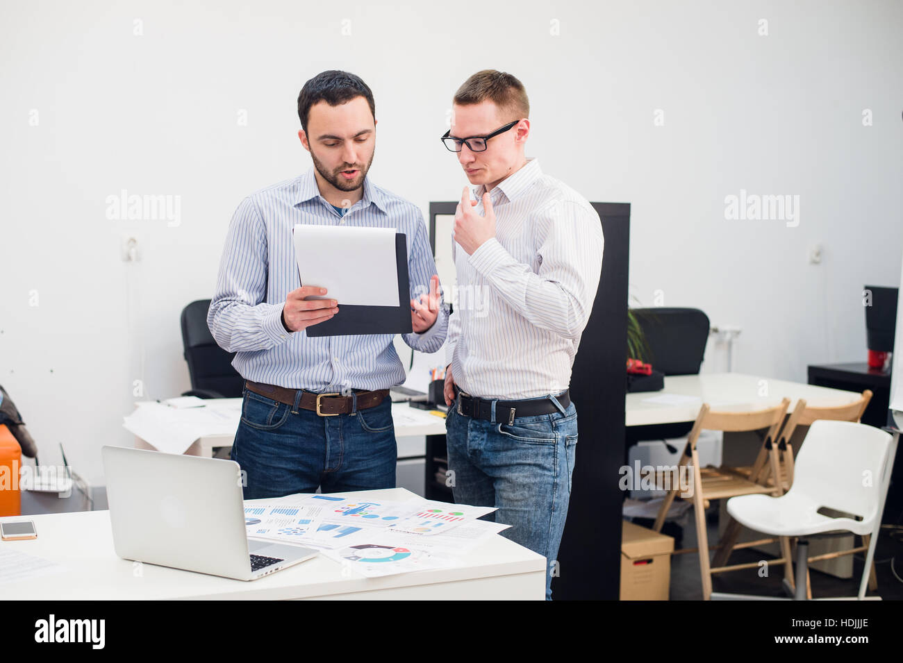 Due caucasici i dirigenti aziendali in abbigliamento casual avente una discussione aziendale in ufficio. Foto Stock
