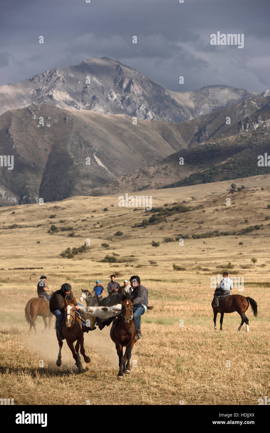 Cavalieri che lottano per il possesso della carcassa di capra nel gioco di kokpar tudabarai in aksu zhabagly Kazakistan Foto Stock