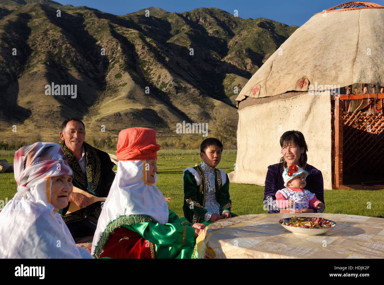 Il canto della famiglia all'aperto con Yurt sotto costruzione e Kungey Alatau sulla montagna del fiume Chilik soggiornare Kazakistan Foto Stock