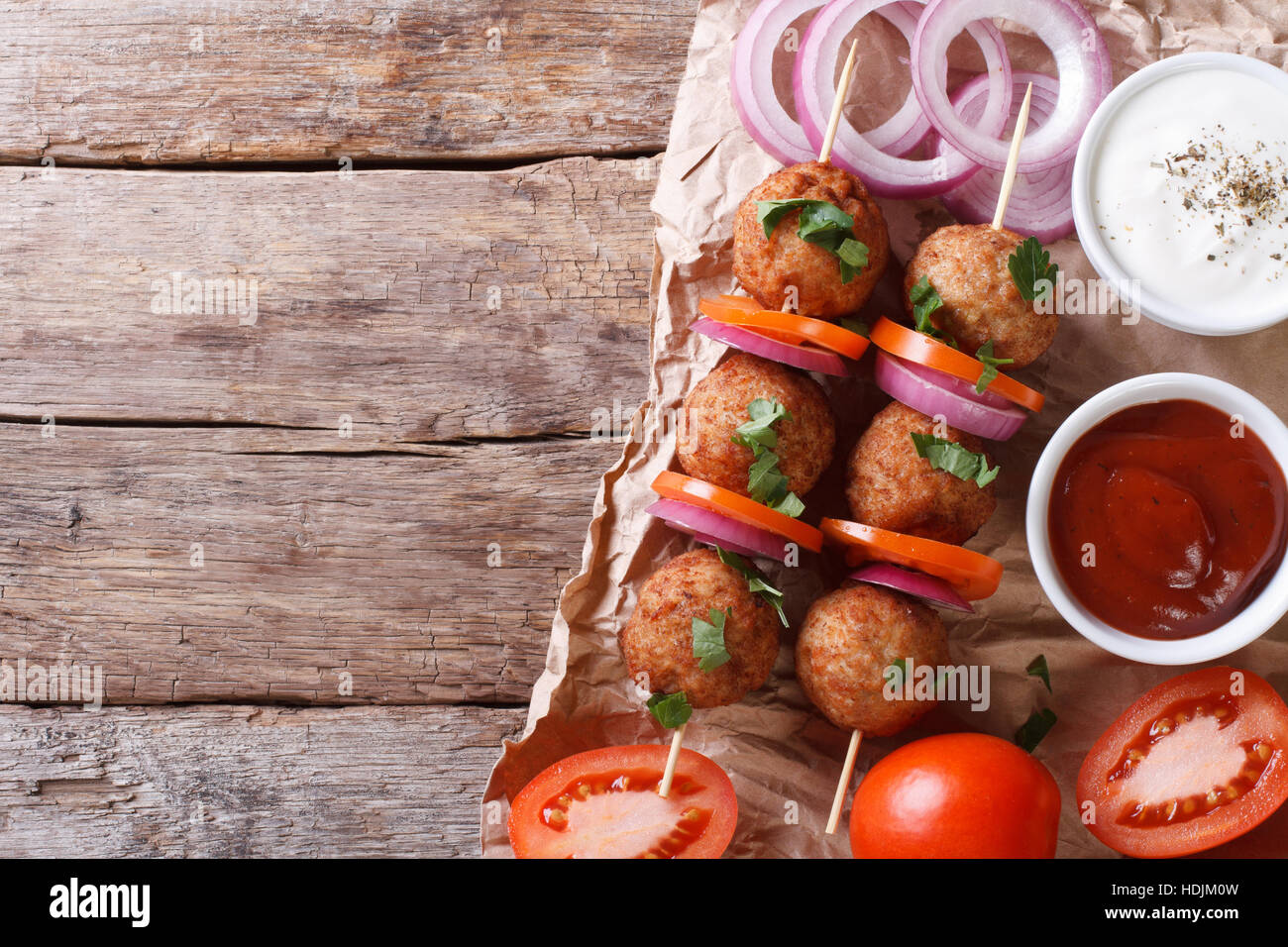 Le polpette di carne arrosto su spiedini e verdure fresche su un vecchio tavolo. vista orizzontale dal di sopra, stile rustico Foto Stock