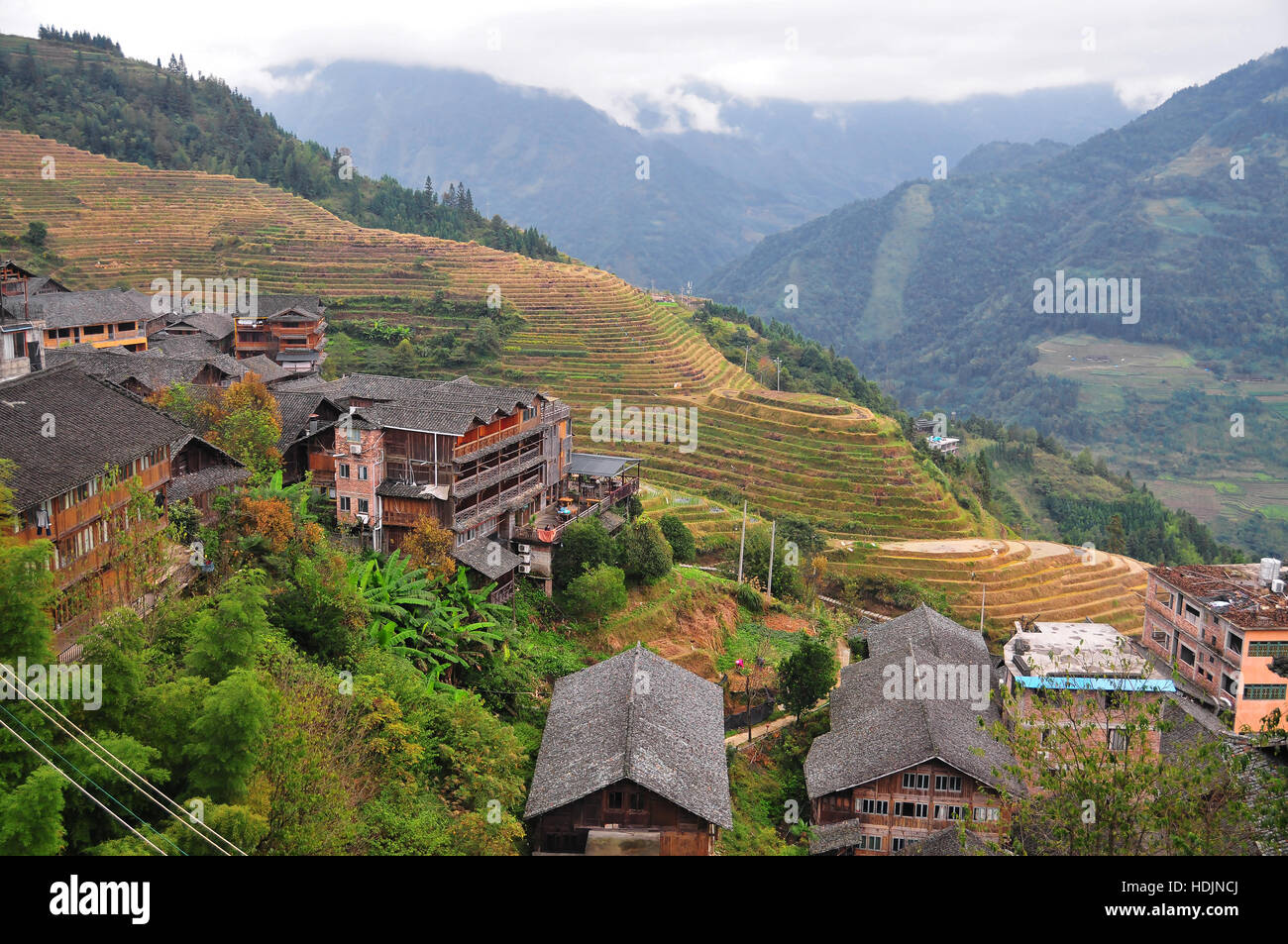 Nuovi alberghi e appartamenti si affacciano le coltivazioni terrazzate sulla Scenic Longji Montagna in Cina Quilin della provincia. Foto Stock