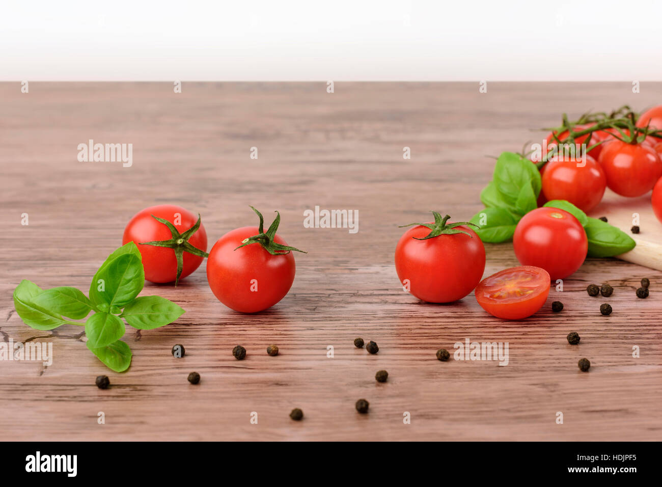 Mini tomaotes sul tavolo di legno con sfondo luminoso. Foto Stock